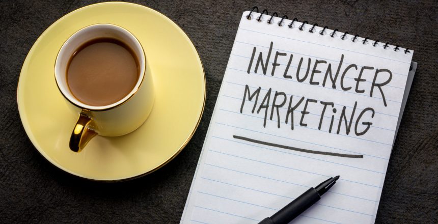 influencer marketing  -  handwriting in a spiral notebook with a cup of tea
